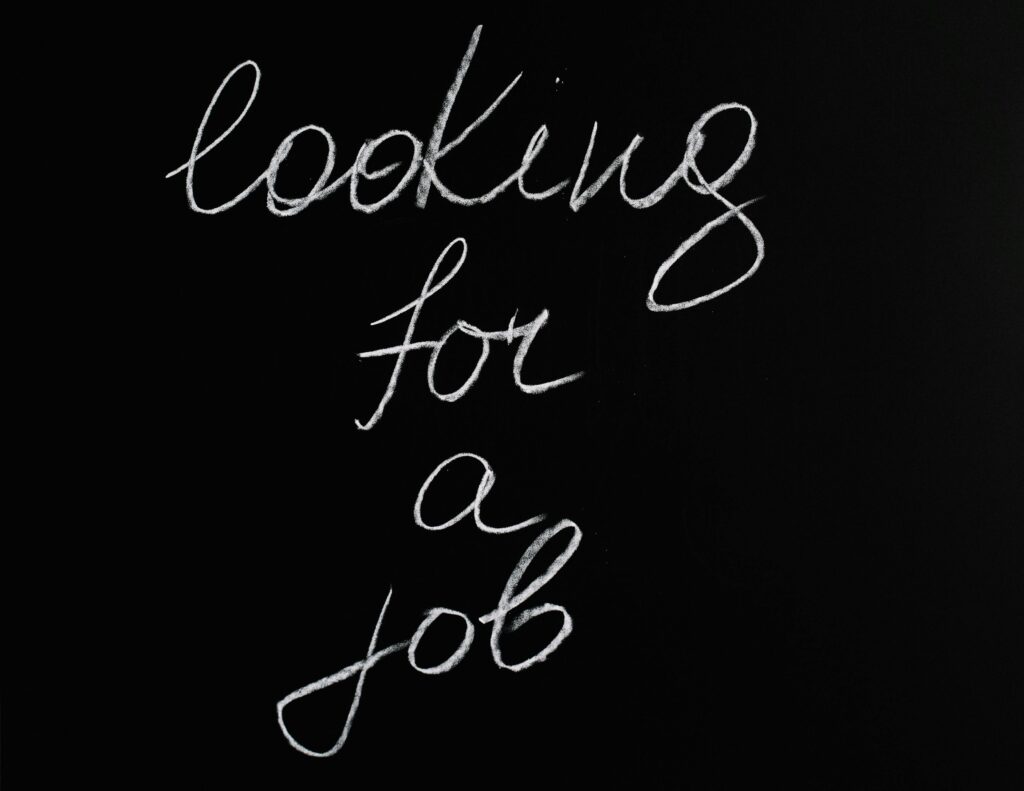 Cursive 'looking for a job' text on a black chalkboard, conveying job search concept.